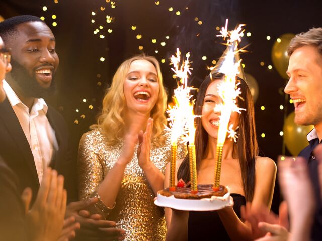 Pretty,Woman,In,Party,Hat,Carrying,Cake,With,Fire,Candles,