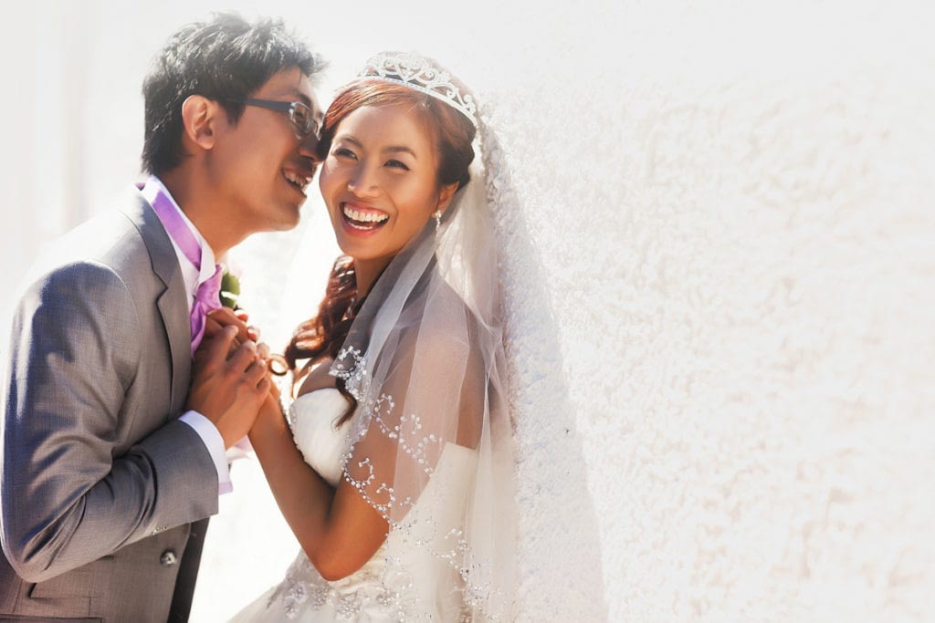Happy,Stylish,Asian,Bride,And,Groom,Smiling,And,Holding,Hands